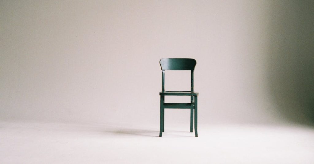 A single black chair in a minimalistic studio setting with a neutral backdrop.